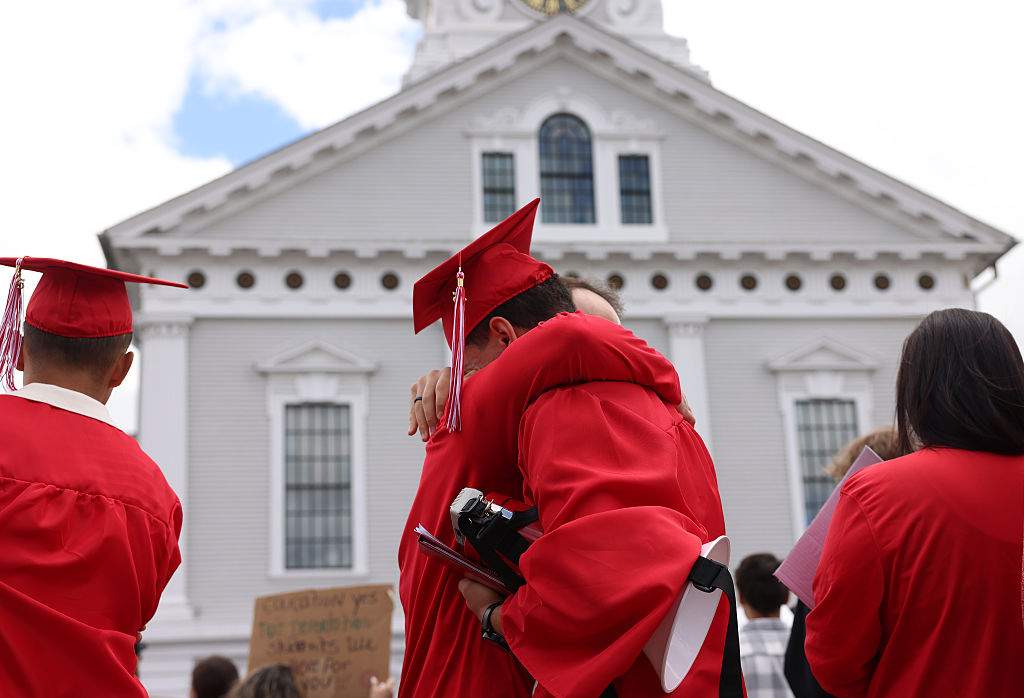 Graduates embrace as they protest outside of Milford Town Hall on June 1, 2025 a day after 18 year-old Marcelo Gomes Da Silva was detained by ICE on his way to volleyball practice.