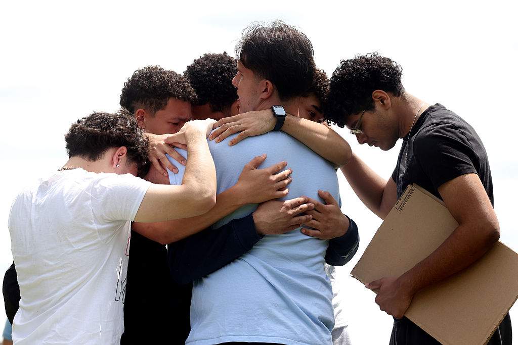 Students embrace outside of Milford High School after walking out of school to protest the detention of Marcelo Gomes Da Silva.