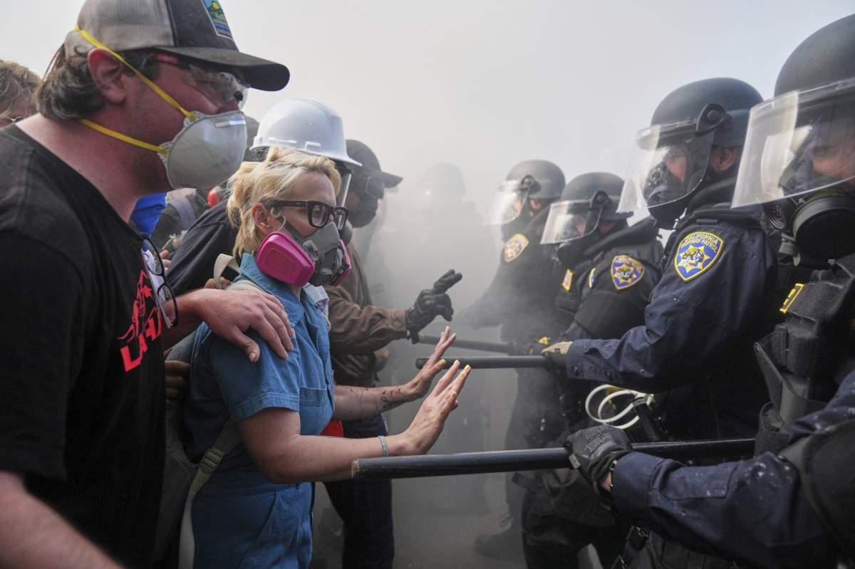 Protesters confront police on the 101 Freeway near the Metropolitan Detention Center of downtown Los Angeles, Sunday, June 8, 2025, following last night's immigration raid protest.