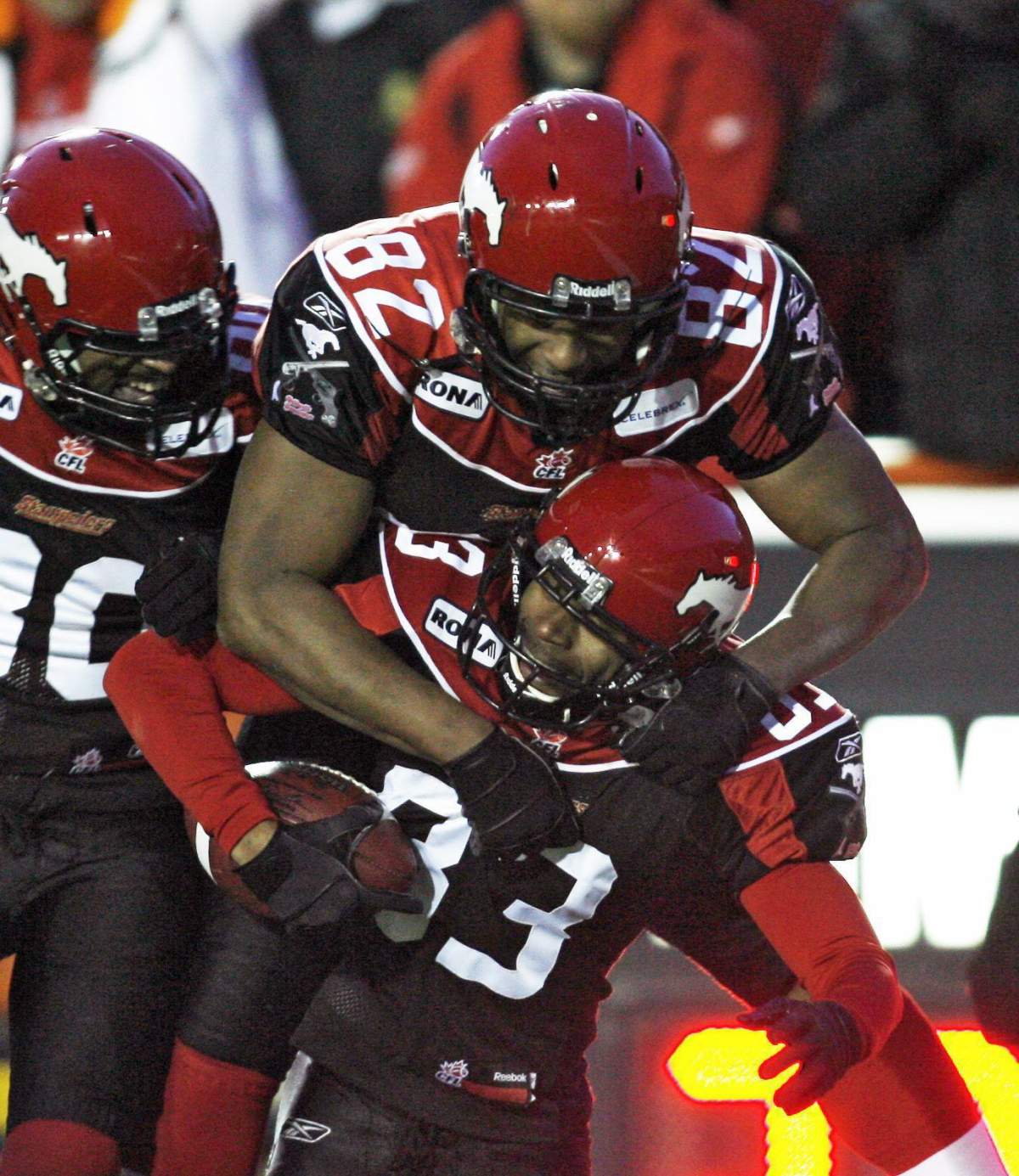 Calgary Stampeders' Romby Bryant, bottom right, celebrates his touchdown with teammates Nik Lewis, top, and Jeremaine Copeland during second half CFL Western semi-final football action against the Edmonton Eskimos in Calgary on Nov. 15, 2009.