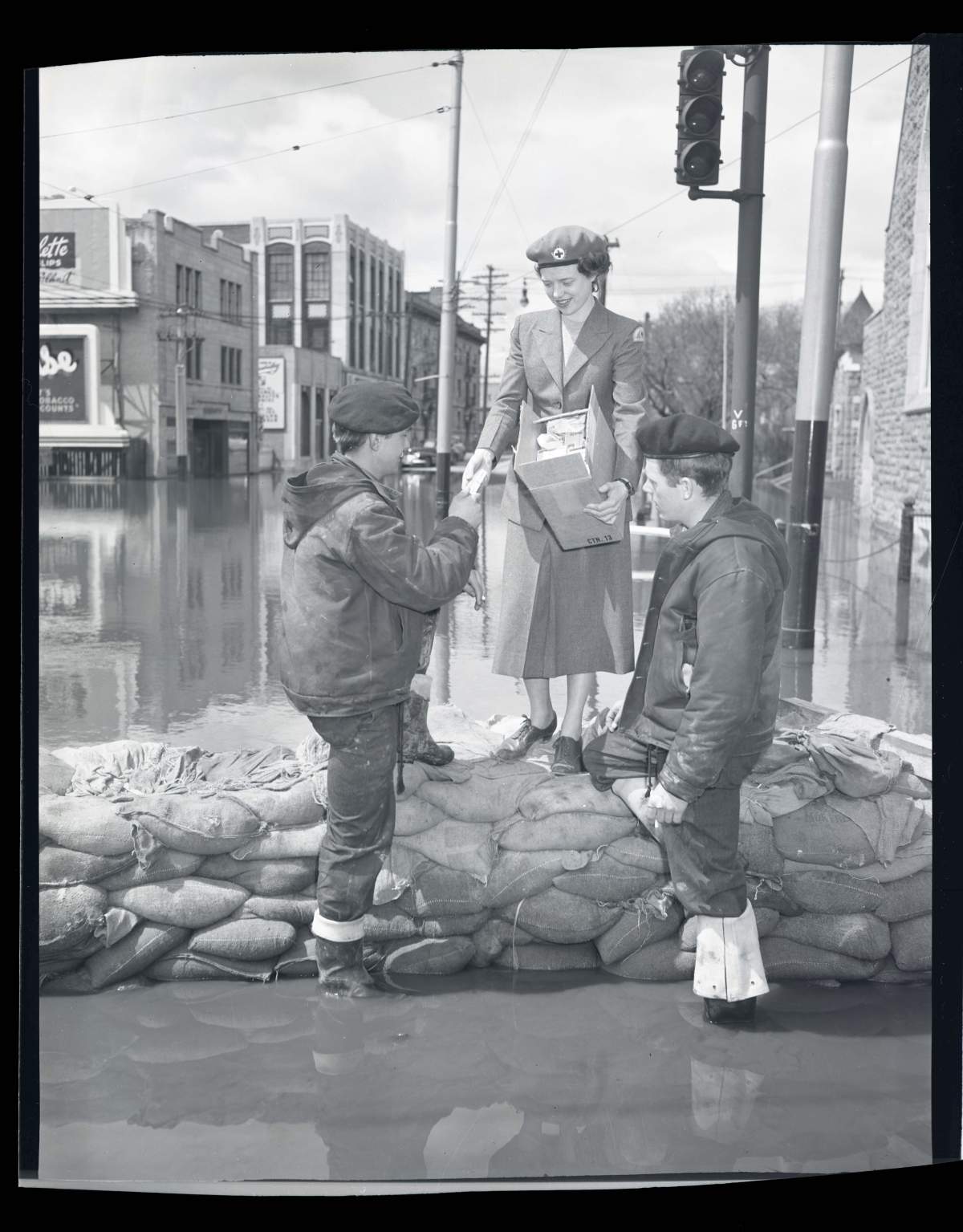The Red Cross hands out packs of cigarettes to workers building dikes during Winnipeg’s flood of 1950.