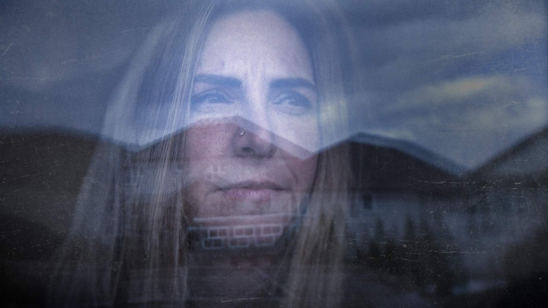 Photo reflection of Kimberly MacDougall staring out window in sombre mood.