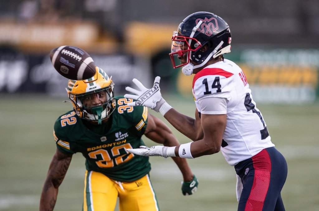 Montreal Alouettes' Charleston Rambo (14) makes the catch as Edmonton Elks' Leonard Johnson (32) chases during first half CFL action in Edmonton, on Thursday June 19, 2025.