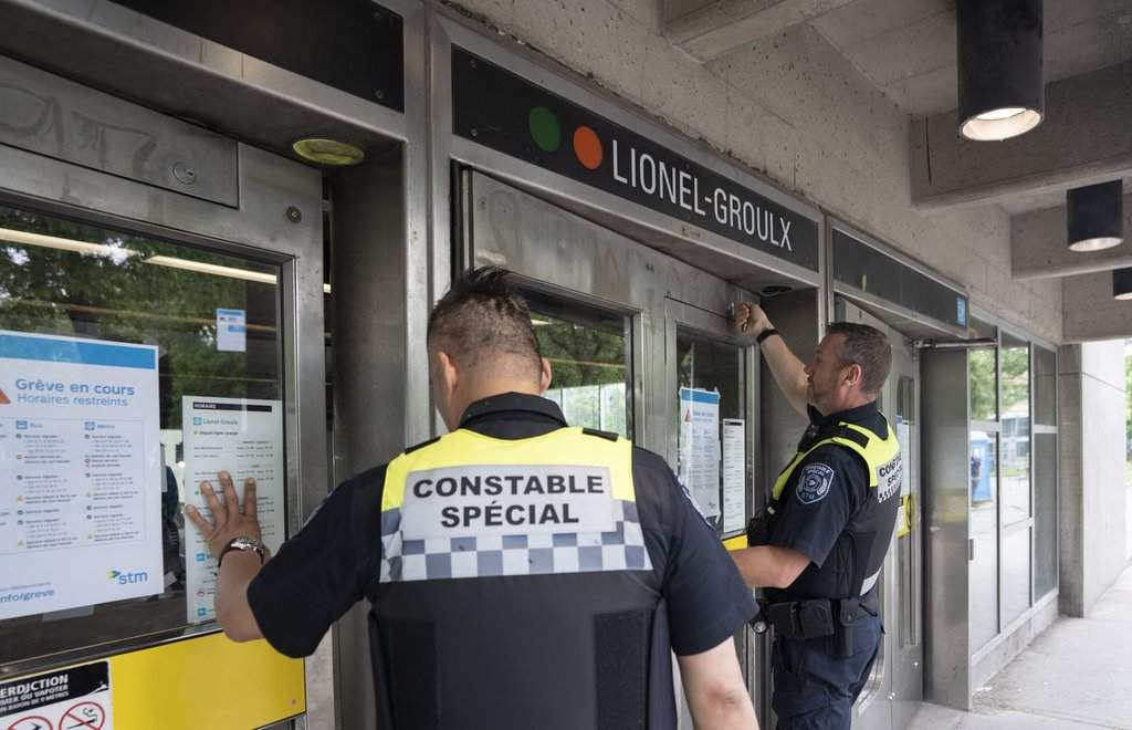 Special constables from the Société de transport de Montréal (STM) lock the doors to the metro station as metro and buses discontinue service due to the strike by maintenance workers in Montreal on Monday, June 9, 2025. THE CANADIAN PRESS/Christinne Muschi.