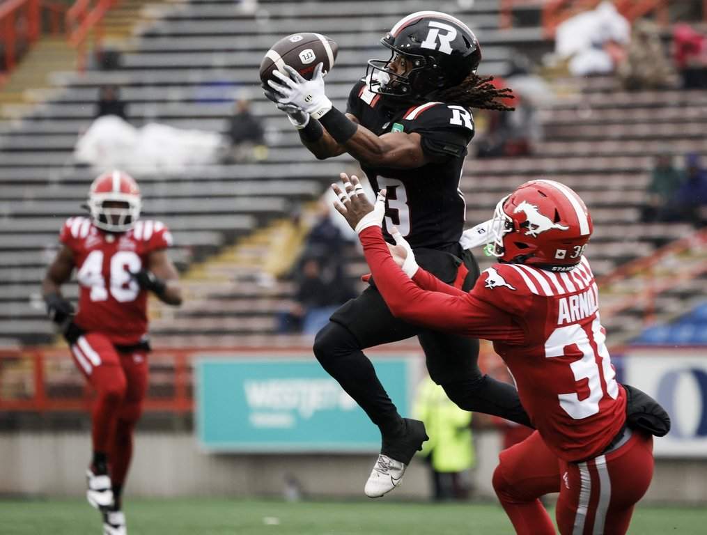 Ottawa Redblacks' Kalil Pimpleton, left, jumps for a pass as Calgary Stampeders' Sheldon Arnold defends during second half CFL football action in Calgary, Saturday, June 21, 2025. THE CANADIAN PRESS/Jeff McIntosh.