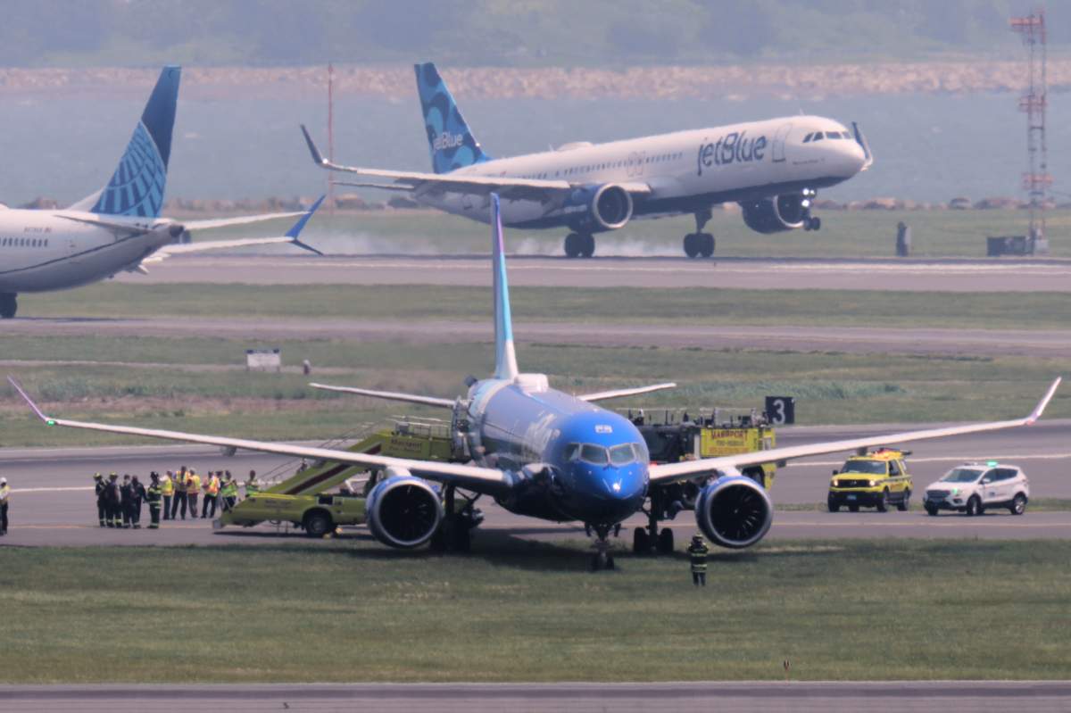 Emergency responders surround a JetBlue plane which rolled off a runway onto a grass area while landing at Logan Airport, Thursday, June 12, 2025, in Boston. 