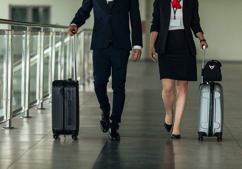 A file photo of a man and a woman pulling their suitcases toward the exit.