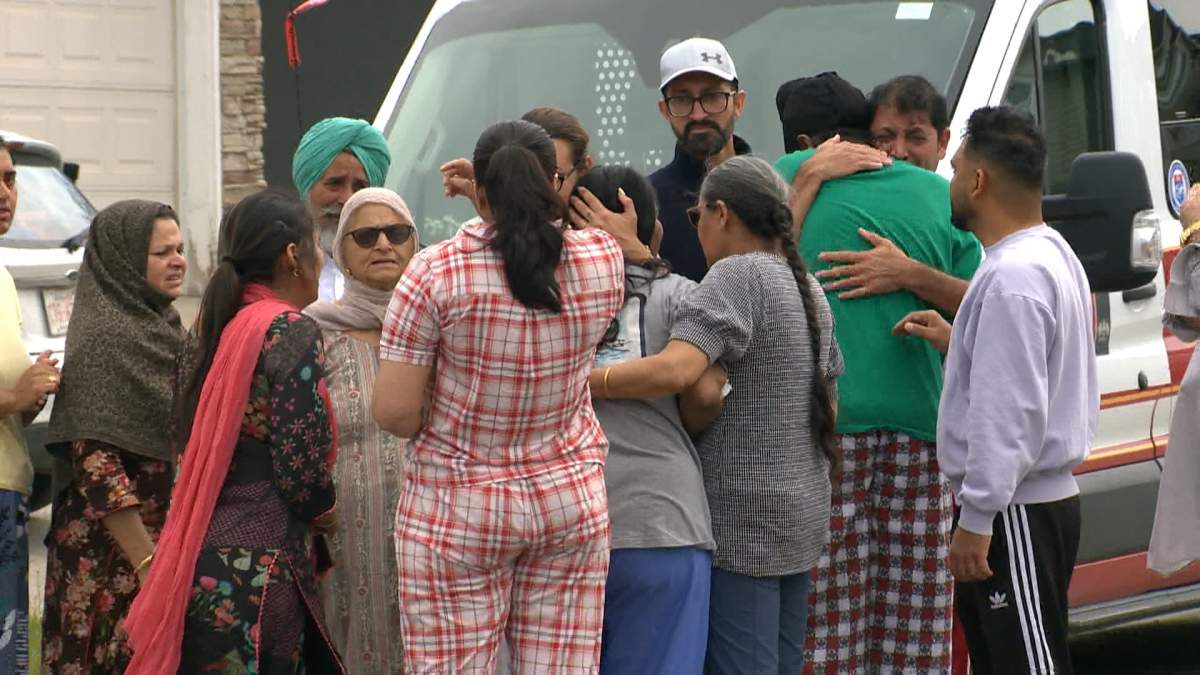 Shortly before noon on Thursday, the two surviving members of the family, Sukhi Gill (in grey) and her 16-year-old son Rohanpreet (in green), returned to the scene of the fire where they were immediately surrounded and comforted by family, friends and neighbours.