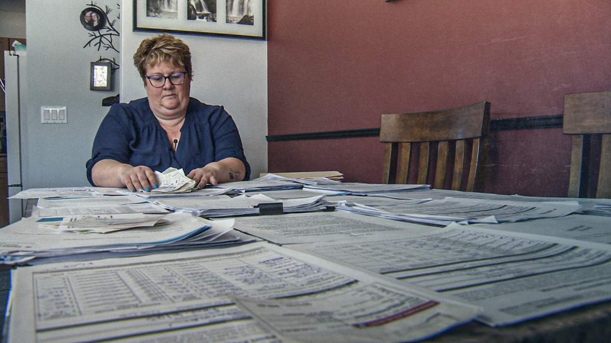 Photo of vaccine injured Shannon Dupont with program mail and documents spread across her entire dining room table.