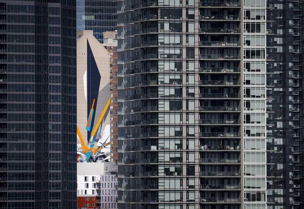 The Calgary Real Estate Board says home sales in the city decreased 16.5 per cent in June compared with last year as higher levels of new listings led to inventory gain. Internationally renowned graffiti artist Mirko Reisser's creation of the world's tallest mural is seen through high-rises in Calgary on June 28, 2022.