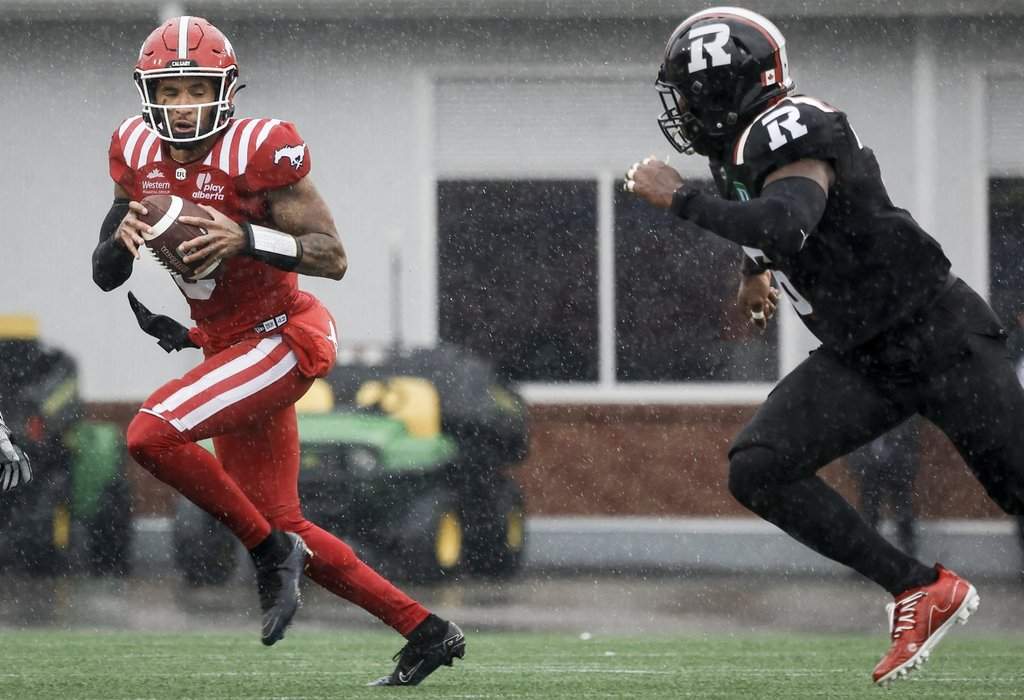 Ottawa Redblacks' Adarius Pickett, right, chases Calgary Stampeders quarterback Vernon Adams during first half CFL football action in Calgary, Saturday, June 21, 2025.