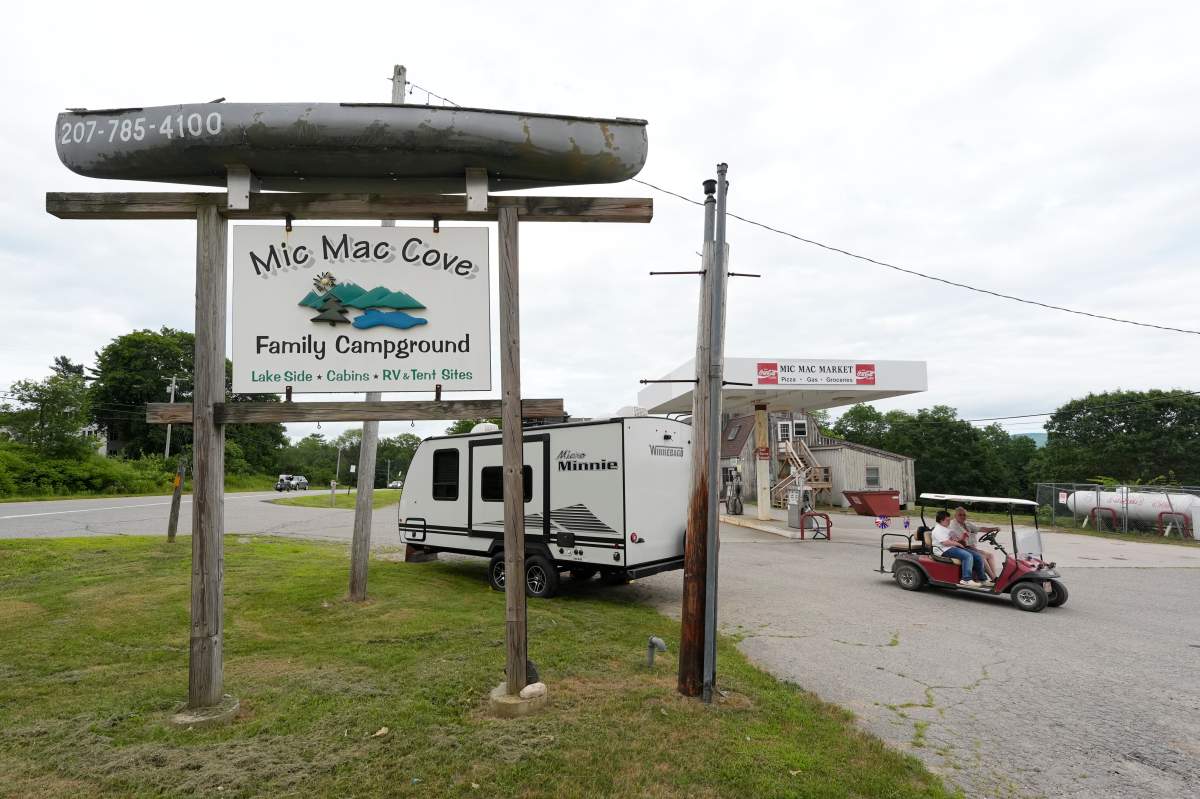 Campers ride a golf cart to the Mic Mac Cove Campground, Wednesday, July 9, 2025, in Union, Maine, where police have used the campground to access Crawford Pond to investigate the murder of a woman last seen paddleboarding on the pond.