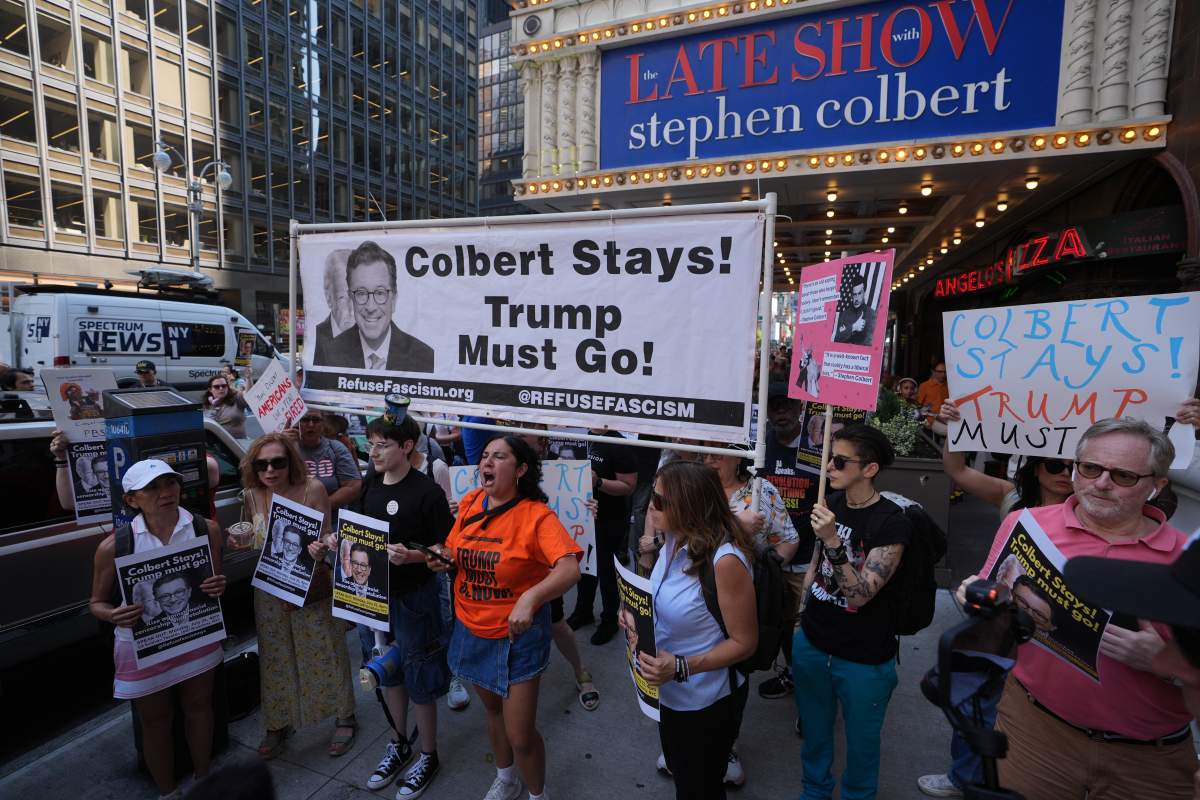 Dozens of anti-Trump protesters gathered outside the Ed Sullivan Theater, home of The Late Show with Stephen Colbert, to protest CBS's reported decision to fire the longtime host. Demonstrators held signs and chanted in support of Colbert, blaming political pressure and criticizing the network's move as a blow to free speech and satire.