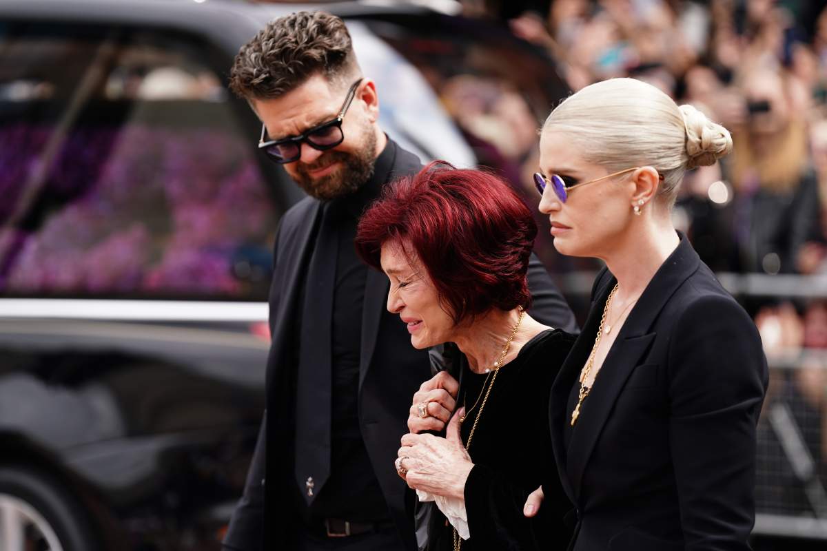 The family of Ozzy Osbourne (left to right) Jack Osbourne, Sharon Osbourne and Kelly Osbourne lay flowers and view the messages and floral tributes left at the Black Sabbath Bridge bench on Broad Street in Birmingham in memory of Black Sabbath frontman Ozzy Osbourne, as his body is brought back to his home city for a procession following his death last week aged 76. Picture date: Wednesday July 30, 2025.