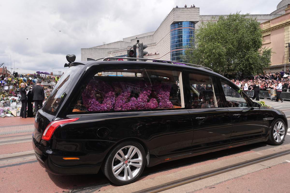 The family of Ozzy Osbourne view the messages and floral tributes left at the Black Sabbath Bridge bench on Broad Street in Birmingham in memory of Black Sabbath frontman Ozzy Osbourne, as his body is brought back to his home city for a procession following his death last week aged 76.