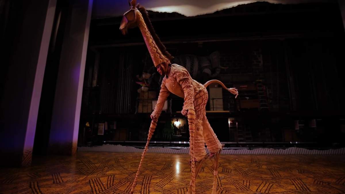 A giraffe puppeteer performing in Broadway Across Canada's "The Lion King."