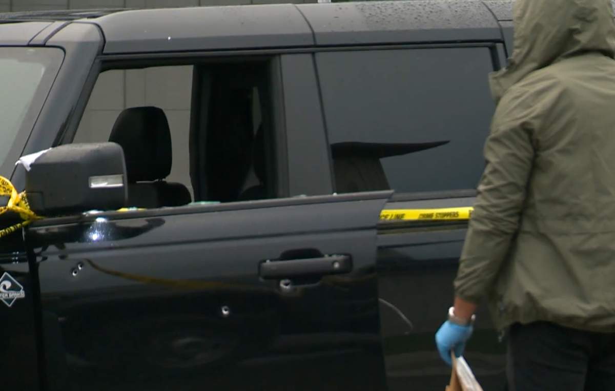 A police investigator examines a Ford Bronco that was left riddled with bullet holes following a shooting outside a residence on Langholm Drive on Monday, July 14, 2025.