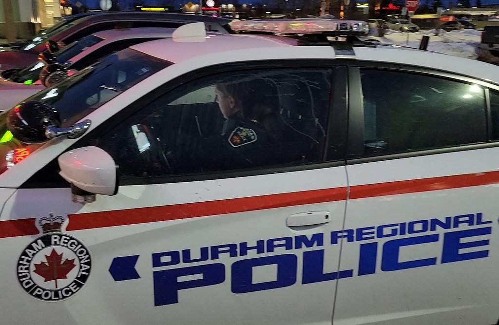 A Durham Regional Police officer looks at the screen in her car at a Bowmanville, Ont. shopping centre parking lot on Tuesday Feb. 28, 2023. 