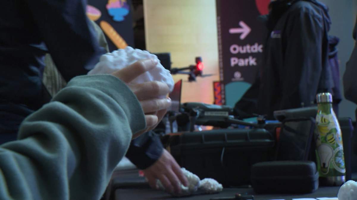 Members of the public examine replicas of some large hailstones on display at an information session hosted by the Northern Hail Project on Tuesday at the Calgary Science Centre.