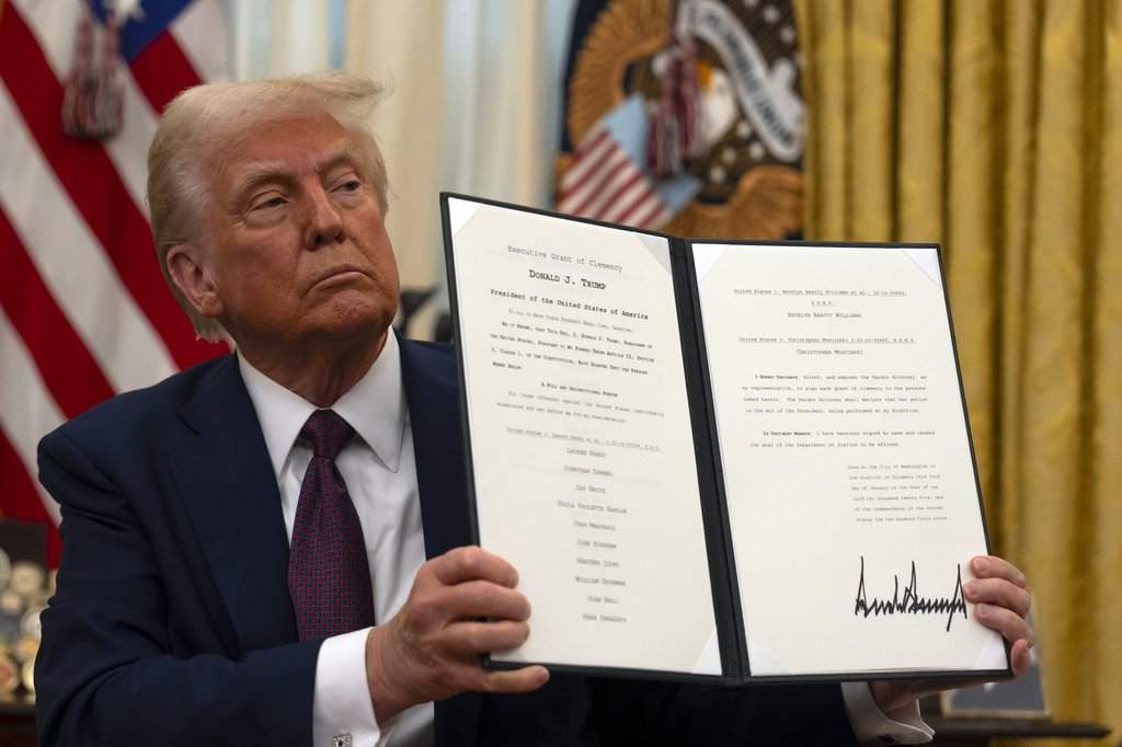 FILE – President Donald Trump holds up a signed executive order relating to clemency for anti-abortion protesters as he signs executive orders in the Oval Office of the White House, Jan. 23, 2025, in Washington.