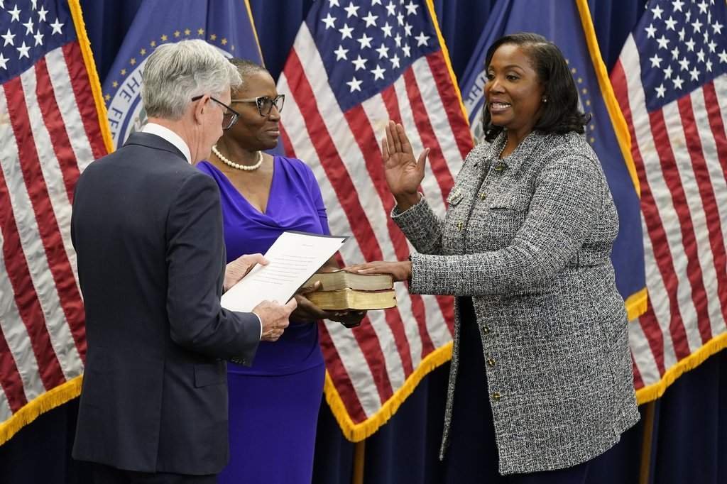 Lisa Cook, right, takes the oath of office to become a member of the Federal Reserve Board, May 23, 2022, in Washington.