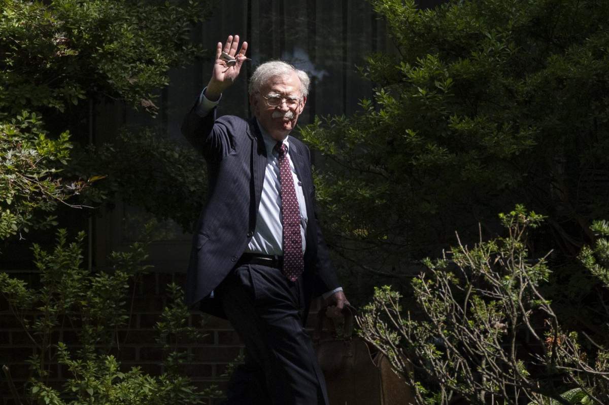 Former national security adviser John Bolton waves as he arrives at his house Friday, Aug. 22, 2025, in Bethesda, Md. (AP Photo/Manuel Balce Ceneta)