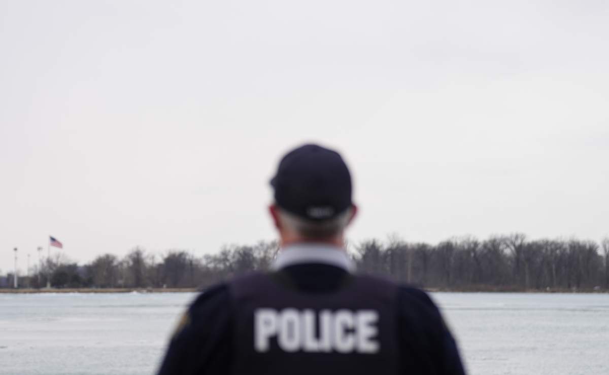 FILE: An RCMP officer in Windsor, Ont. looks over the Detroit River, on Friday, March 7, 2025. THE CANADIAN PRESS/Chris Young.