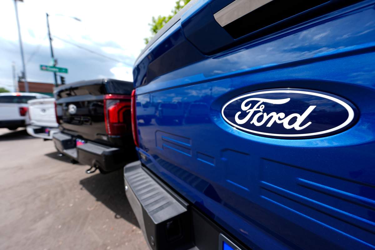 A line of 2024 F150 pickup trucks sit at a Ford dealership.