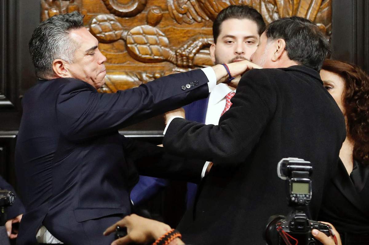 Senator Alejandro Moreno (L) of the Institutional Revolutionary Party (PRI) throws a punch at Senator Gerardo Fernandez Norona of the National Regeneration Movement Party (Morena) during a session of the Permanent Commission of the Senate in Mexico City on August 27, 2025. Mexican senators came to blows on Wednesday following a heated debate over alleged calls from the opposition for the United States to intervene militarily against drug cartels.