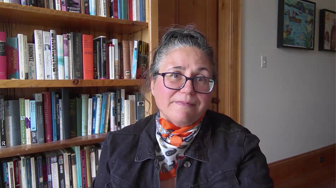 Photo of Jennifer Keelan sitting in front of book case.