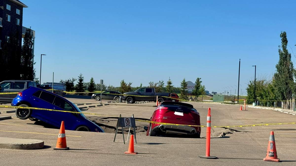 Two SUVs were left leaning into a sinkhole in the MacEwan Greens parking lot, located on the west side of Leduc, on Friday Aug. 1, 2025.