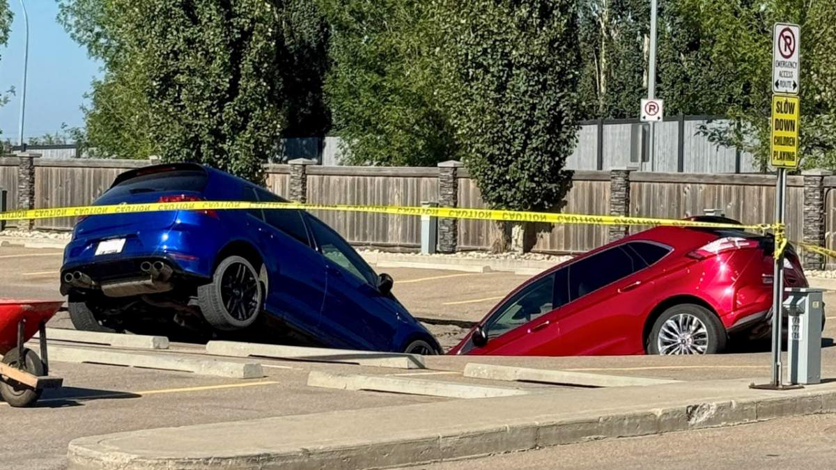 Two SUVs were left leaning into a sinkhole in the MacEwan Greens parking lot, located on the west side of Leduc, on Friday Aug. 1, 2025.