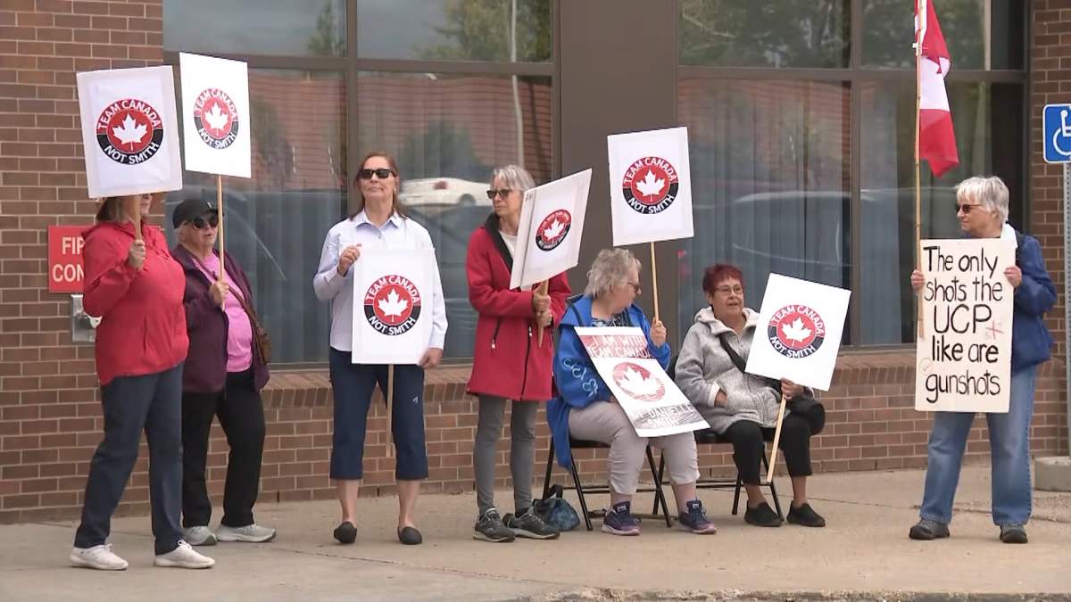 A group of demonstrators gather outside a town hall hosted by the UCP's Alberta Next panel in Edmonton on Thursday to show their opposition to the idea of Alberta separation.