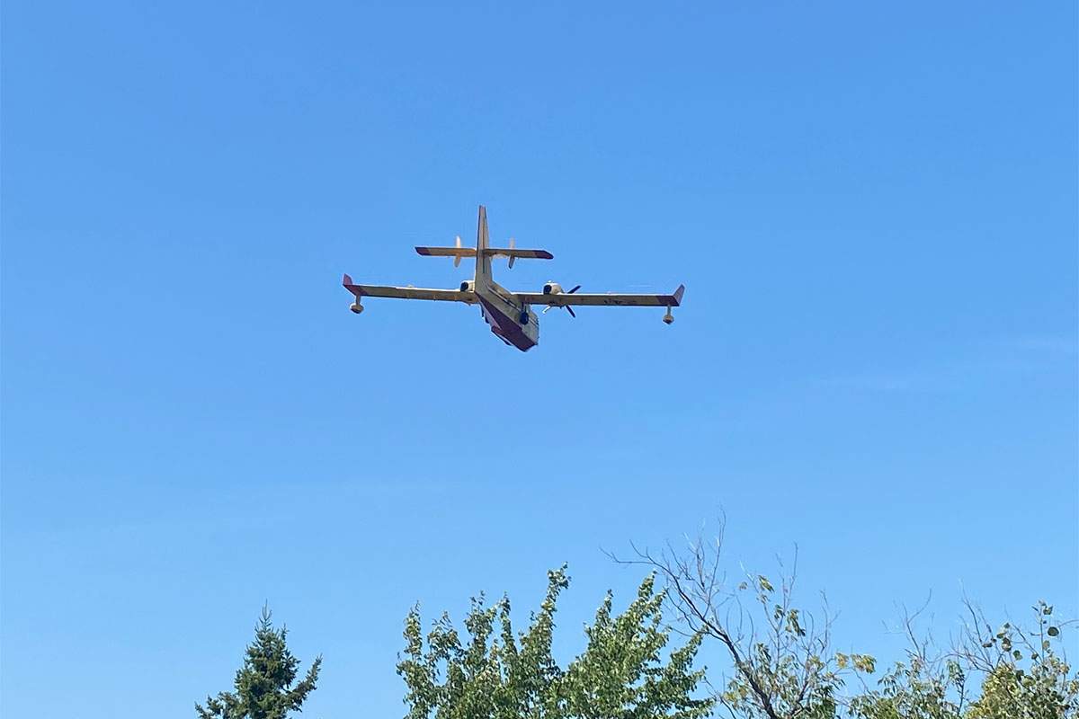 A water bombers flies toward a wildfire near Miramichi, N.B.