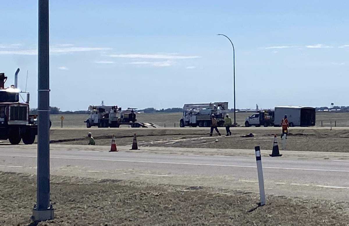 Crews work alongside Highway 1, trying to repair transmission line damage from a thunderstorm.