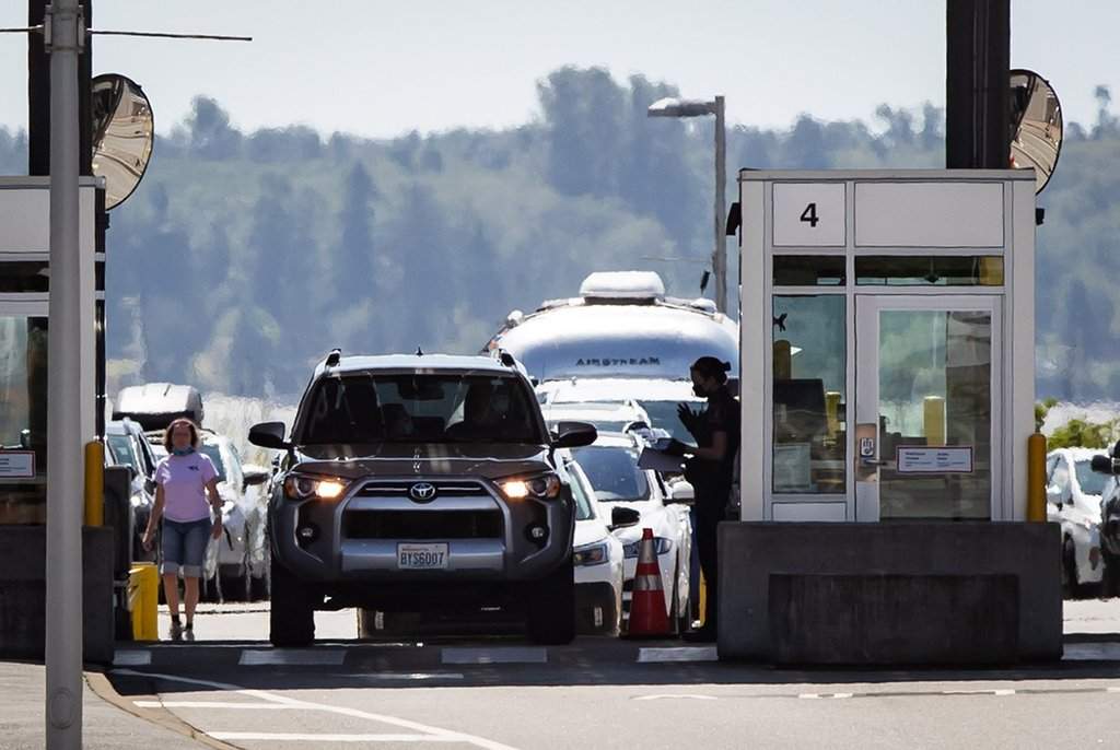 A Canada Border Services Agency officer speaks to a motorist entering Canada at the Douglas-Peace Arch border crossing, in Surrey, B.C., on Monday, August 9, 2021. THE CANADIAN PRESS/Darryl Dyck.
