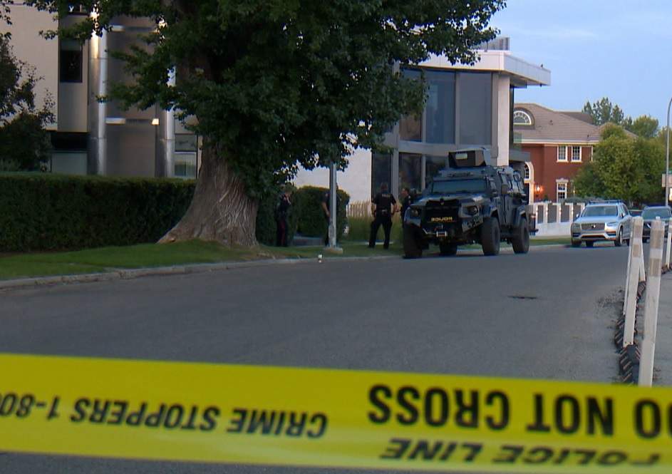 A Calgary police tac team vehicle sits on the side of Crescent Road northwest, where police say officers where shot at when they tried to arrest a man on a Canada-wide warrant.