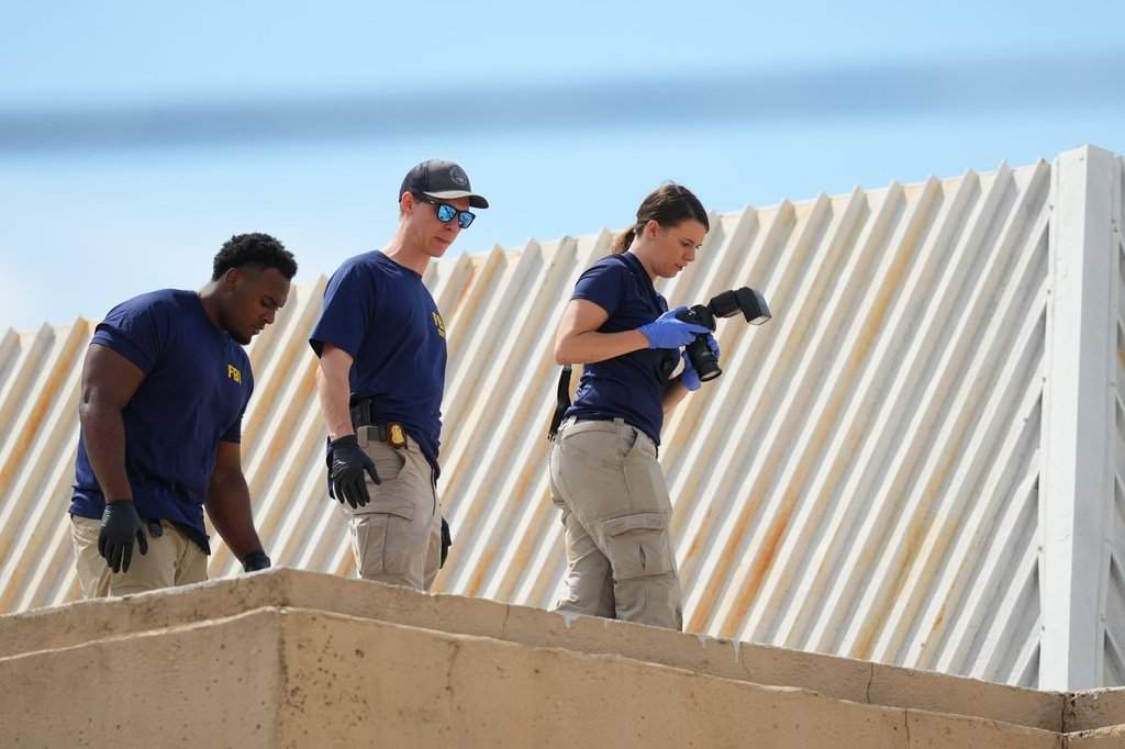Law enforcement agents investigate the roof of an apartment building near the scene of a shooting at a U.S. Immigration and Customs Enforcement office in Dallas on Wednesday, Sept. 24, 2025. (AP Photo/Julio Cortez)