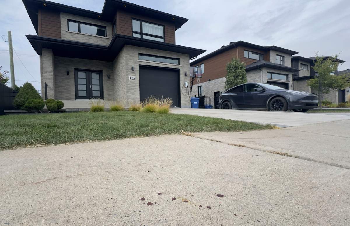 Drops of blood are seen on the sidewalk outside a home where one person died after being shot by police on Montreal’s South Shore of Longueuil, Que., on Monday, September 22, 2025.