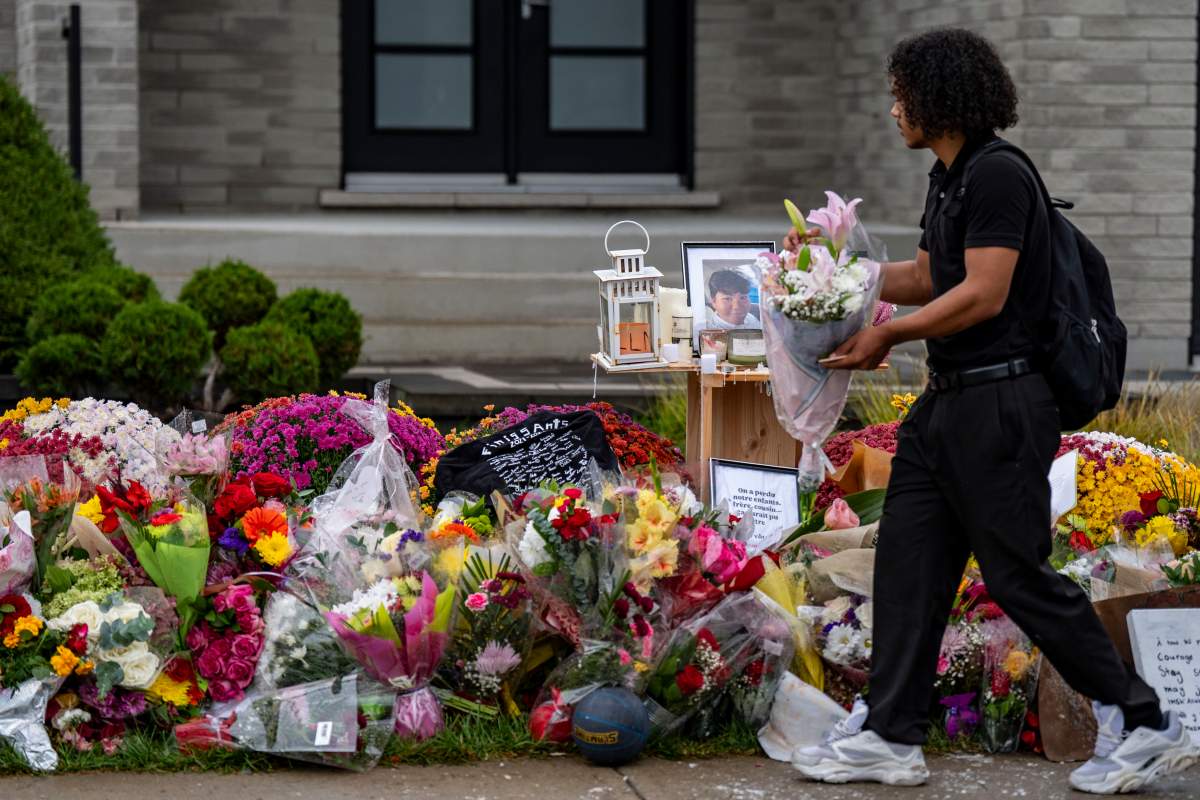 A teenager pays his respect at the memorial site for classmate Nooran Rezayi, who was killed on Sunday afternoon after police responded to a report of a group of armed people in a quiet suburban neighbourhood in Longueuil, Que., south of Montreal on Thursday, September 25, 2025.