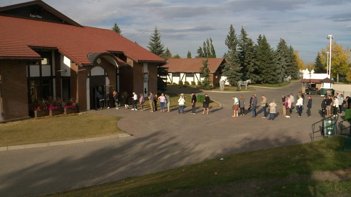 People wait in a lineup to get into the final Alberta Next town hall in Calgary on Monday.