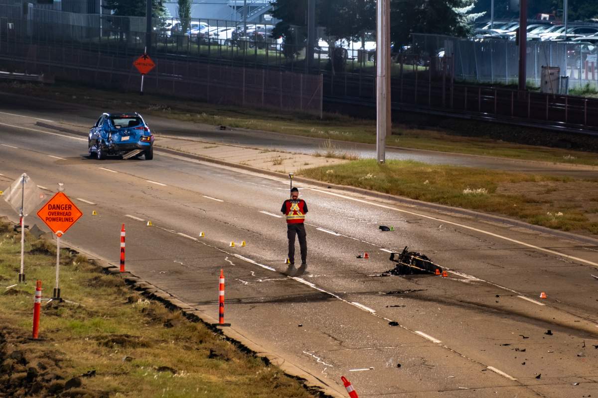 A Calgary Police officer surveys the scene of a fatal motorcycle crash on Macleod Trail