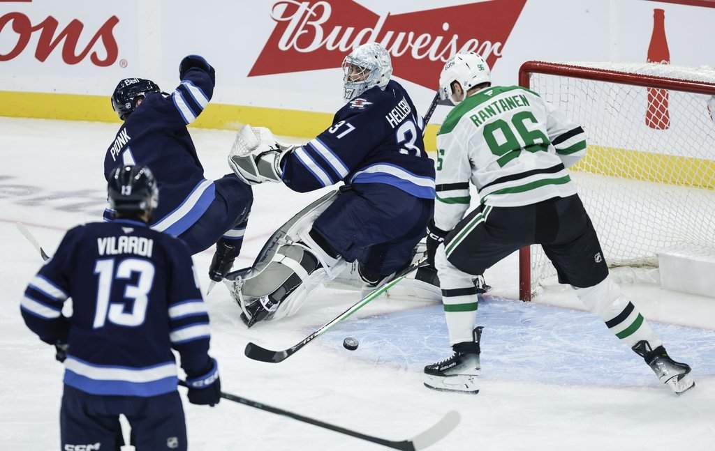 Dallas Stars' Mikko Rantanen (96) scores on Winnipeg Jets goaltender Connor Hellebuyck (37) during first period NHL action in Winnipeg on Thursday, October 9, 2025. THE CANADIAN PRESS/John Woods.