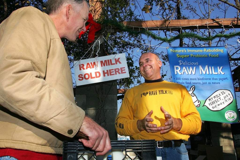 FILE - Veterinarian Patrick Smith, left, discusses raw milk with dairyman and producer Mark McAfee at the Farmer's Market in Fresno, Calif., on Saturday, Dec. 22, 2007. (AP Photo/Gary Kazanjian, File).