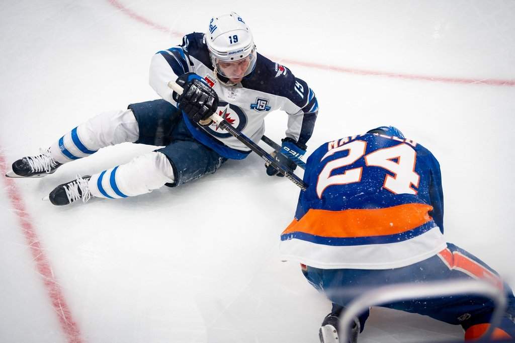 Winnipeg Jets forward Jonathan Toews (19) collides with New York Islanders defenseman Scott Mayfield (24) during the first period of an NHL hockey game, Monday, Oct. 13, 2025, in Elmont, N.Y.