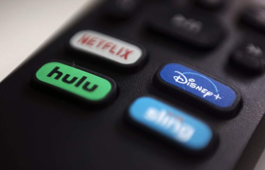 FILE - The logos for streaming services Netflix, Hulu, Disney Plus and Sling TV are pictured on a remote control on Aug. 13, 2020, in Portland, Ore. (AP Photo/Jenny Kane, File).