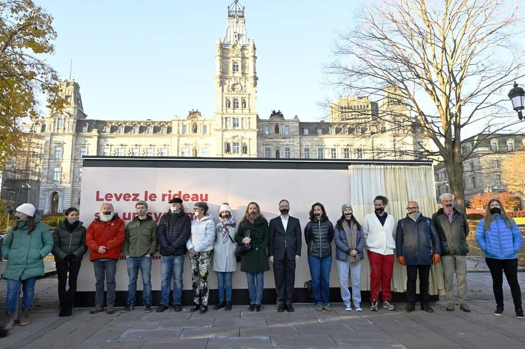 Quebec doctors stand with their mouths taped as a sign of protest against the new Bill 2, in front of the national assembly, in Quebec City, on Tuesday, Oct. 28, 2025.