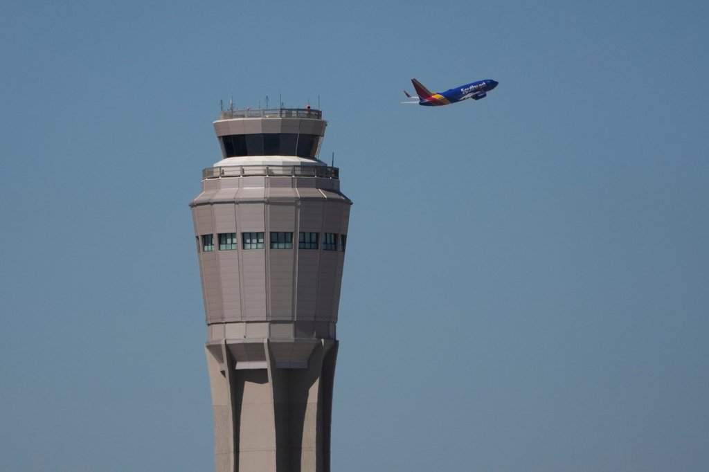 FILE - A plane takes off near the air traffic control tower at Harry Reid International Airport, Tuesday, Oct. 7, 2025, in Las Vegas.