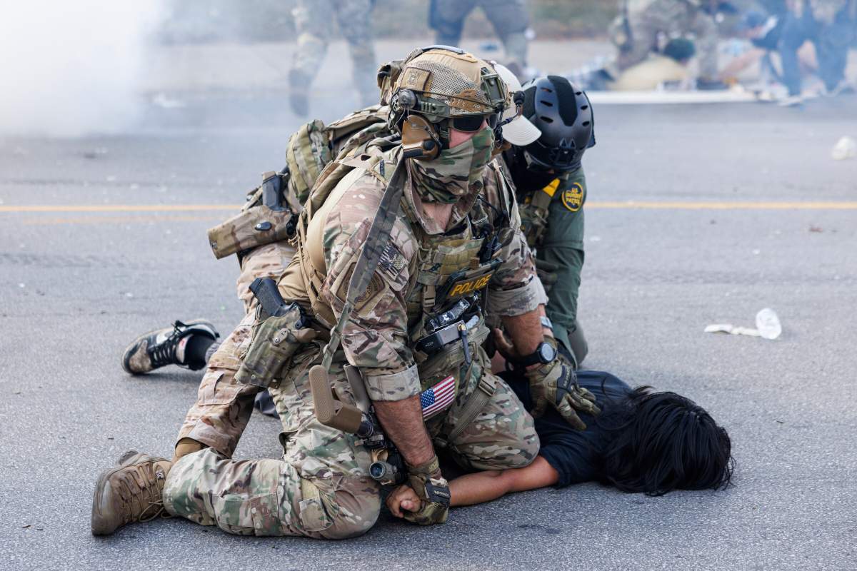 Federal officers hold down a protester in the Brighton Park neighborhood of Chicago, on Saturday, Oct. 4, 2025, after protesters learned that U.S. Border Patrol shot a woman Saturday morning on Chicago's Southwest Side.