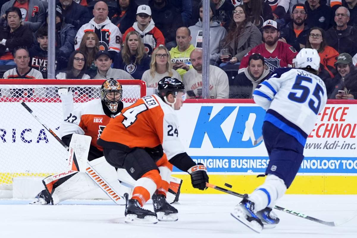Winnipeg Jets' Mark Scheifele (55) scores a goal against Philadelphia Flyers' Nick Seeler (24) and Samuel Ersson (33) during the second period of an NHL hockey game, Thursday, Oct. 16, 2025, in Philadelphia. (AP Photo/Matt Slocum).